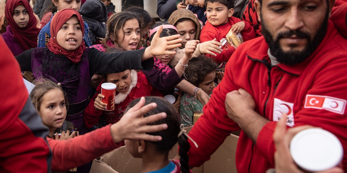 SARMADA, SYRIA - NOVEMBER 26: Displaced Syrian children wait to receive toys handed out by Turkish Red Crescent employees at a camp for displaced people supported by the Turkish Red Crescent on the outskirts of Idlib, on November 26, 2021 in Sarmada district, Idlib Province, Syria. The province's population has swelled over the course of Syria's 10-year civil war, as the rebel-held northwest became a refuge for Syrians with nowhere else to go. People here live in a patchwork of tents, brick homes and other improvised structures, some in camps supported by the Turkish Red Crescent, which provides food, blankets and toys. Amid the pandemic and looming threat of violence, humanitarian organizations and local authorities have struggled to meet these communities' overwhelming needs. (Photo by Chris McGrath/Getty Images)