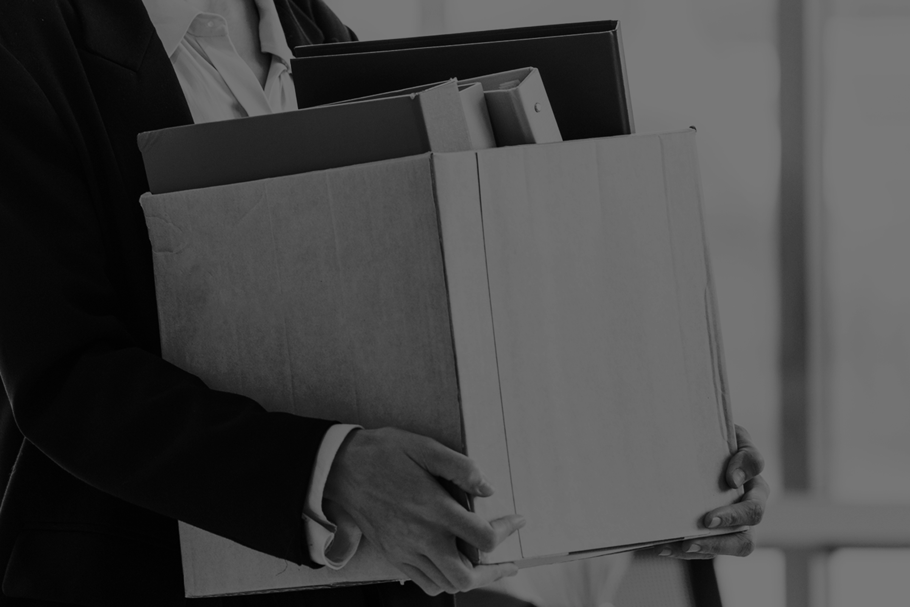 An resigning employee carrying a box of belongings