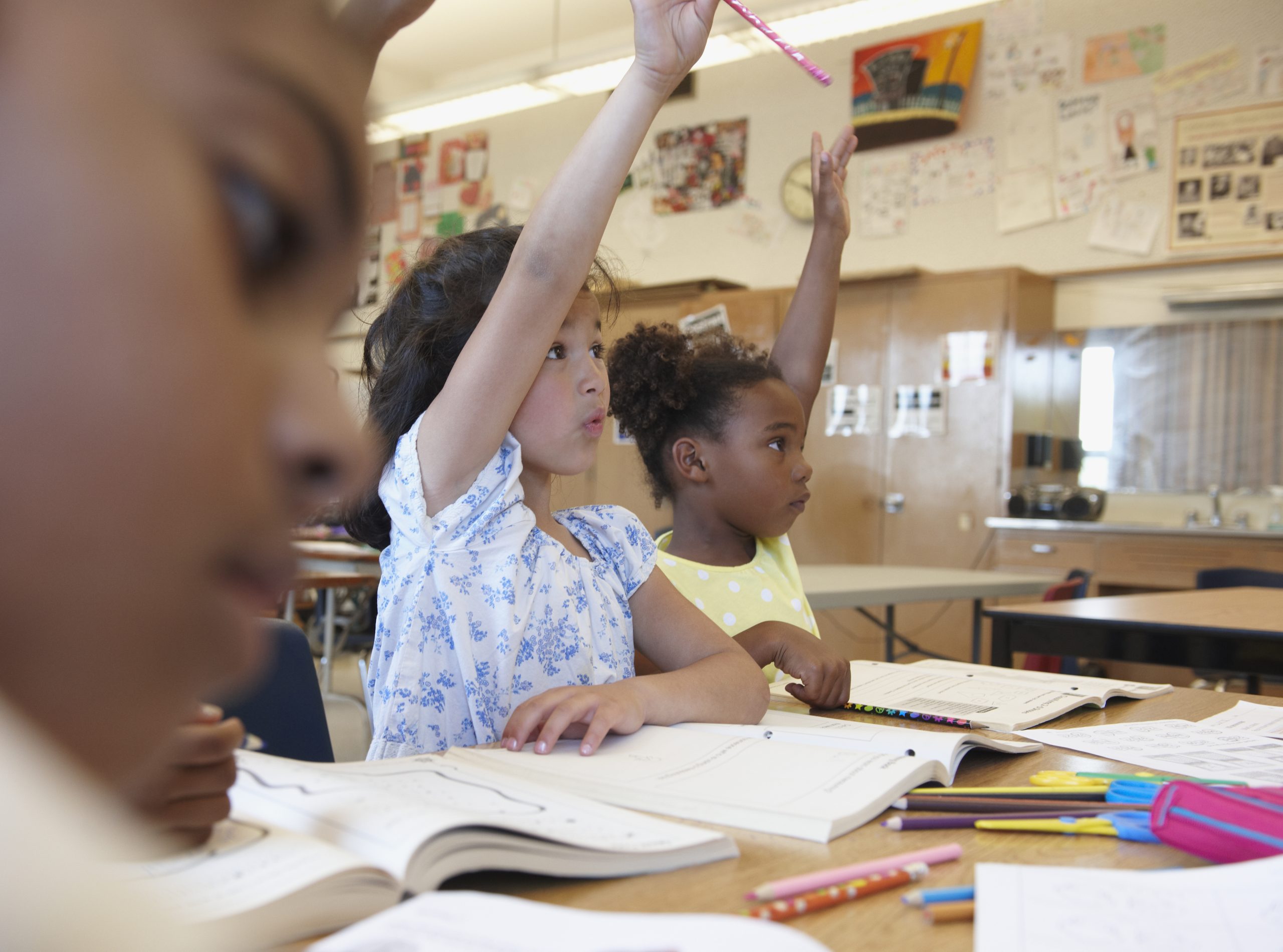 Children raising their hands in a classroom