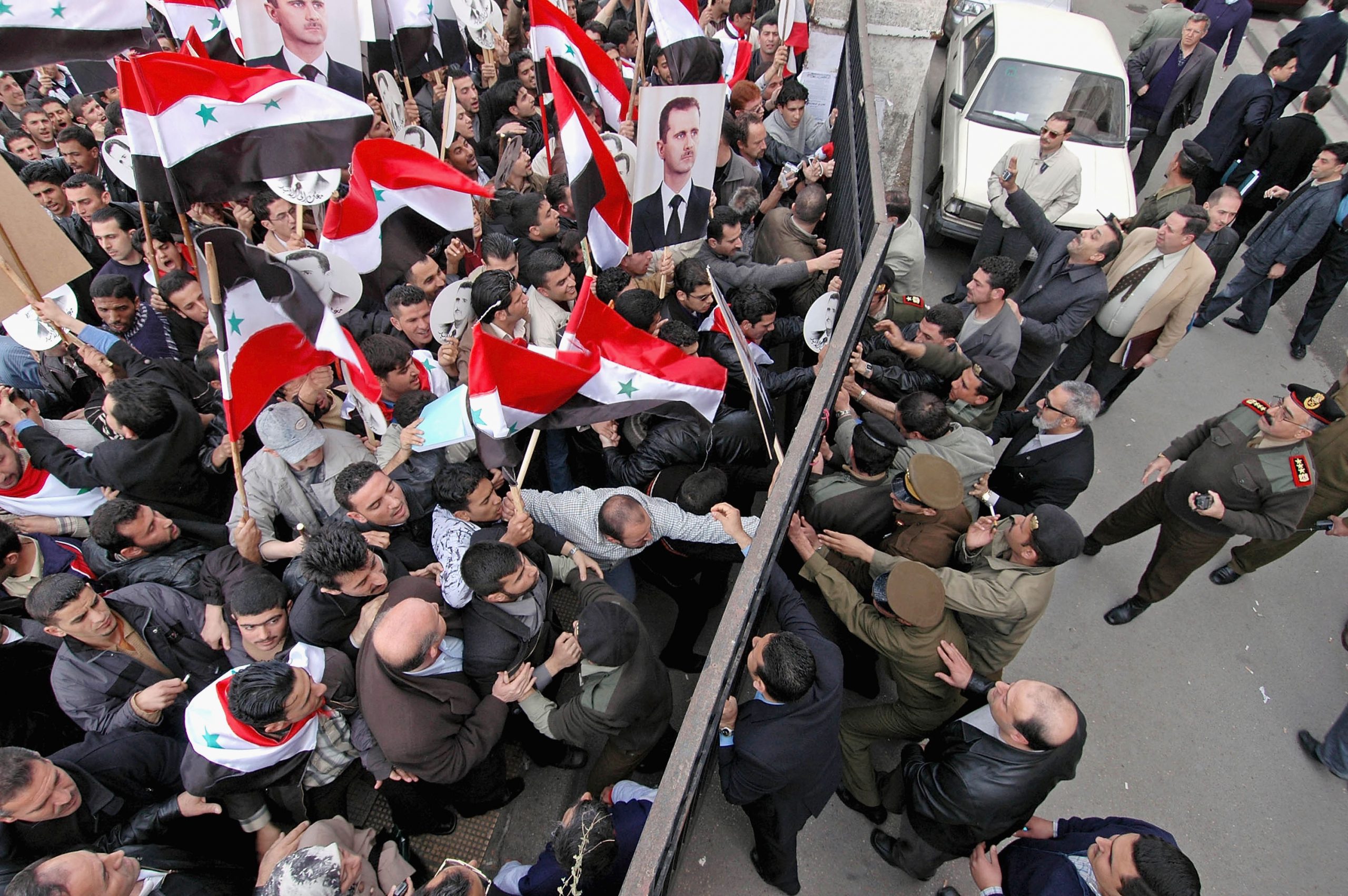 DAMASCUS, SYRIA - MARCH 10:  A pro-Assad demonstration quickly puts an end to a pro-democracy demonstration in front of the justice palace on March 10, 2005 in Damascus, Syria. The Lebanese Parliament emboldened by pro-Syrian demonstrations in Beirut voted to re-elect Lebanon's pro-Syrian Prime Minister, Omar Karami, who was forced stand down by pressure from opponents of Syria's occupation.  (Photo by Jeroen Kramer/Getty Images)
