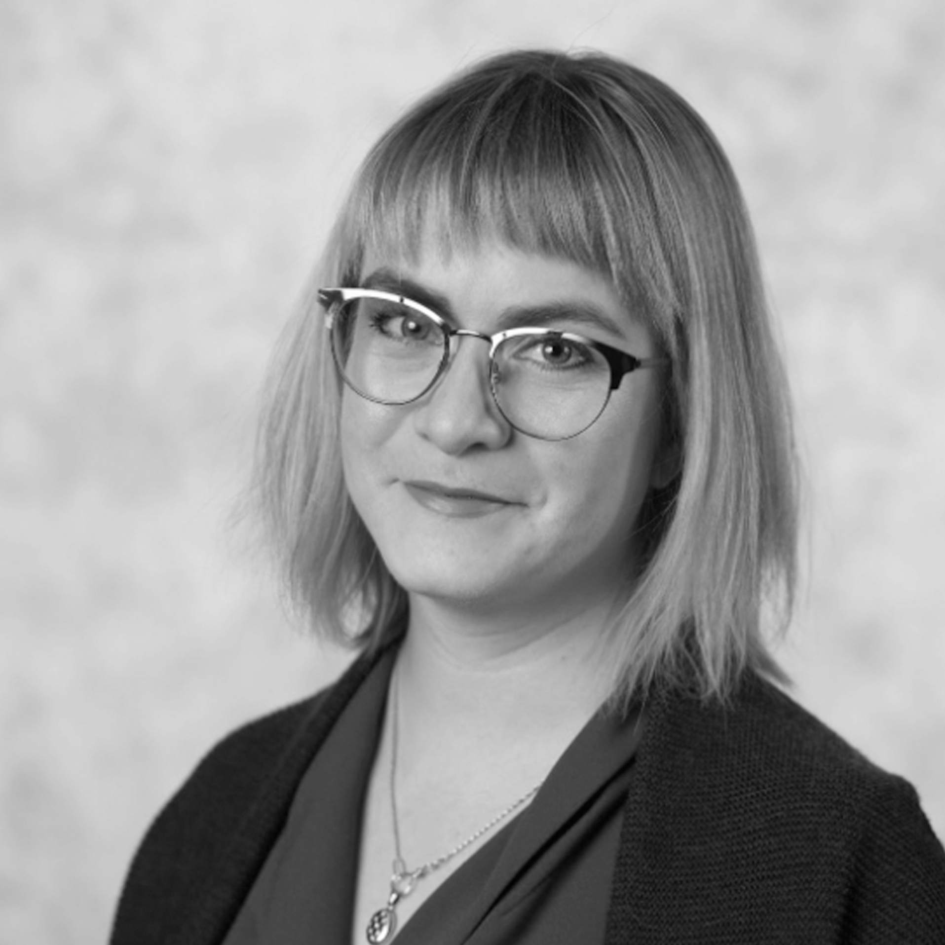 a woman wearing glasses and a black jacket