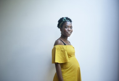 Indoors portrait of a beautiful pregnant woman, dressed in yellow.