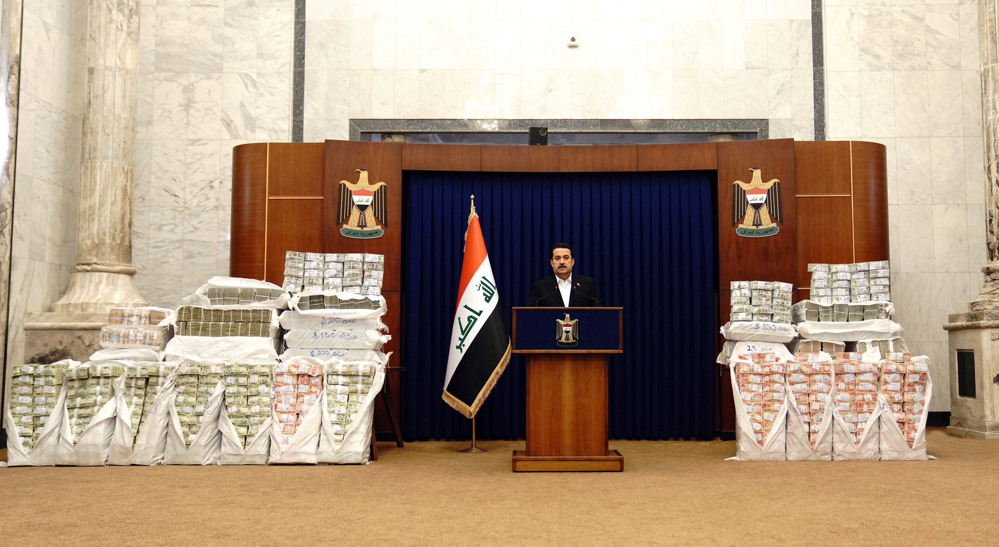 Iraqi prime minister Mohammed Shia al-Sudani stands in front of piles of money recovered from the “heist of the century.” Source: Twitter page of the Iraqi prime minister’s office, November 27, 2022,