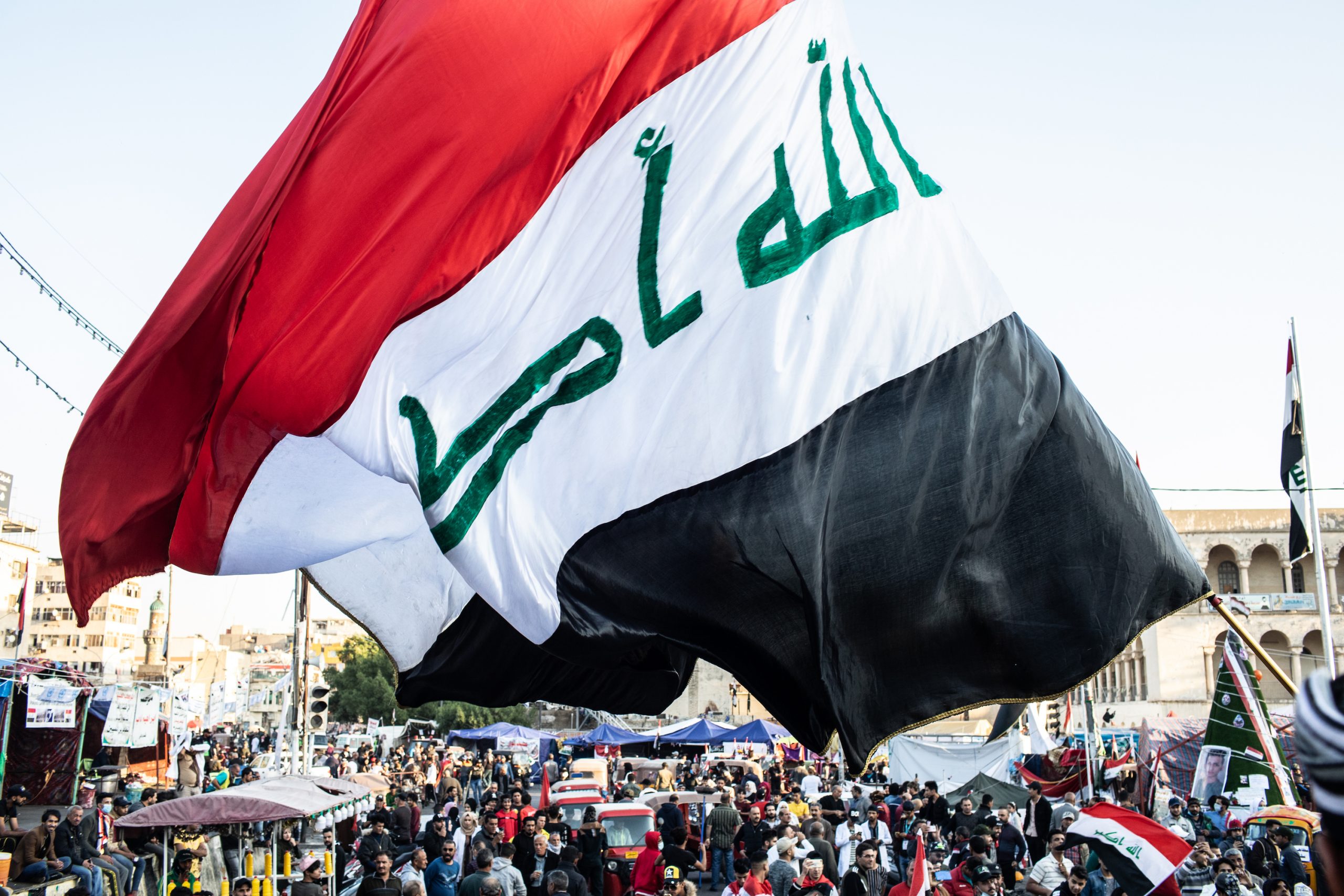BAGHDAD, IRAQ - NOVEMBER 21: A flag waves over Tahrir Square on Nov. 21, 2019 in Baghdad, Iraq. Thousands of demonstrators have occupied Baghdad's center Tahrir Square since October 1, calling for government and policy reform. For many, Tahrir Square - which demonstrators are calling 