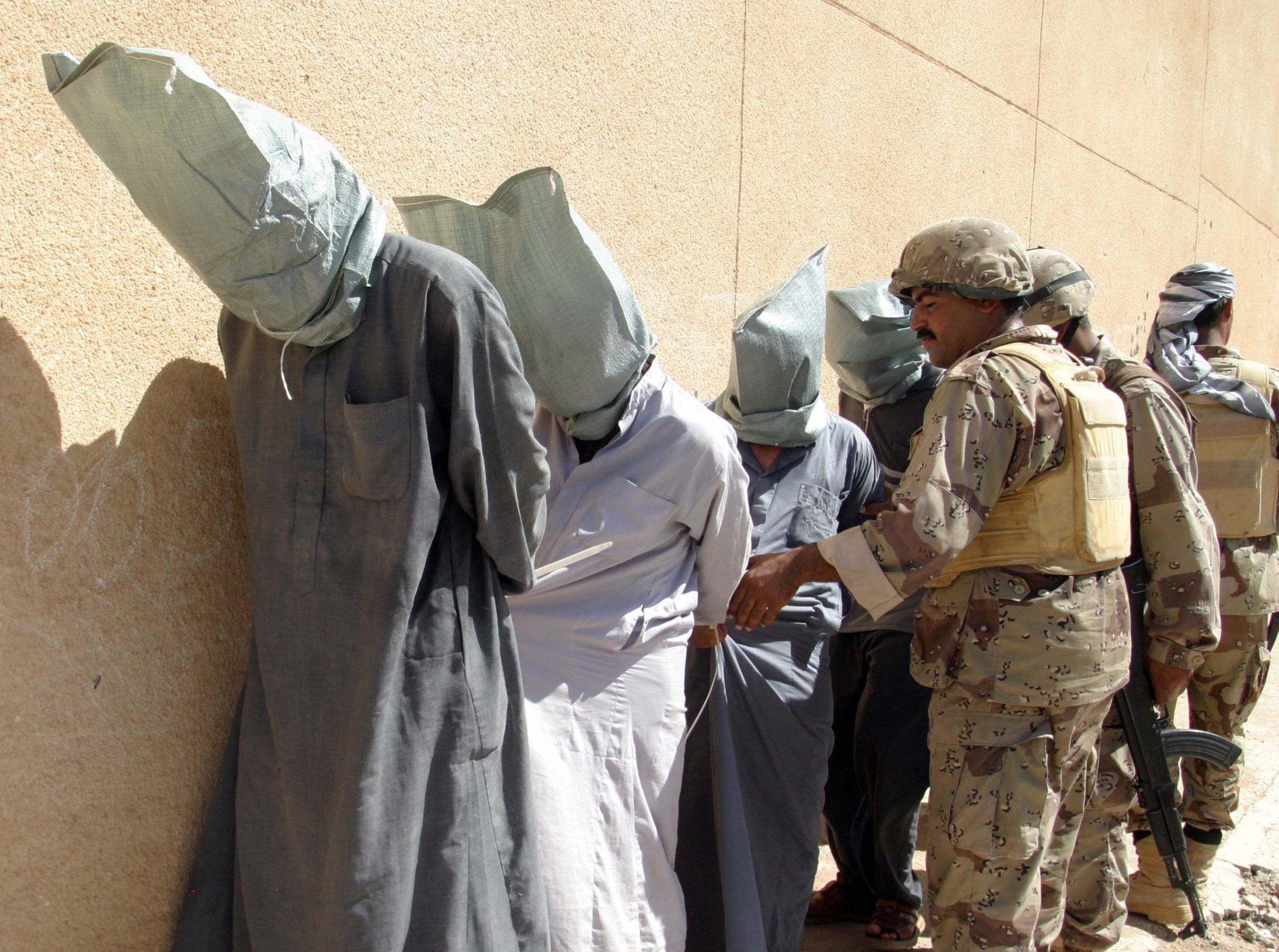TALL AFAR, IRAQ - SEPTEMBER 14:  Iraqi soldiers detain suspected insurgents in the al-Qadisiyah neighborhood after house-to-house searches September 14, 2005 in Tall Afar, Iraq. Tall Afar is located approximately 93 miles east of the Syrian border and about 260 miles northwest of Baghdad, Iraq. (Photo by Akram Saleh/Getty Images)
