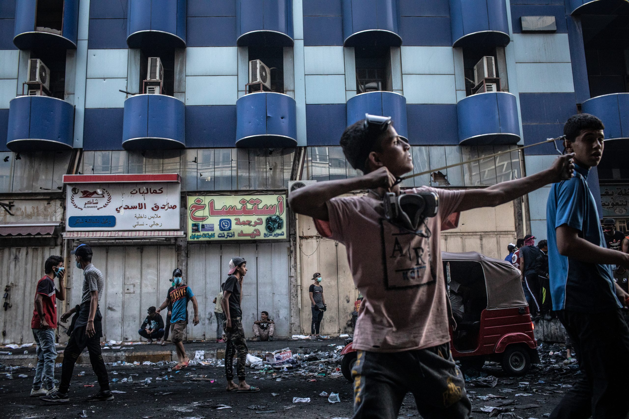 BAGHDAD, IRAQ - NOVEMBER 15: A young Iraqi protestor lauches rocks with a slingshot at Iraqi security forces near Al-Senak bridge on Nov. 15, 2019 in Baghdad, Iraq. Al-Senak bridge has been a contested area where protestors have continued to advance their movements pushing northwest as Iraqi security forces aim to maintain their position. Since Oct. 1, thousands of demonstrators have occupied various parts of Baghdad including its main bridges and Tahrir Square calling for government and policy reform. For many, Tahrir Square, which protesters are calling 