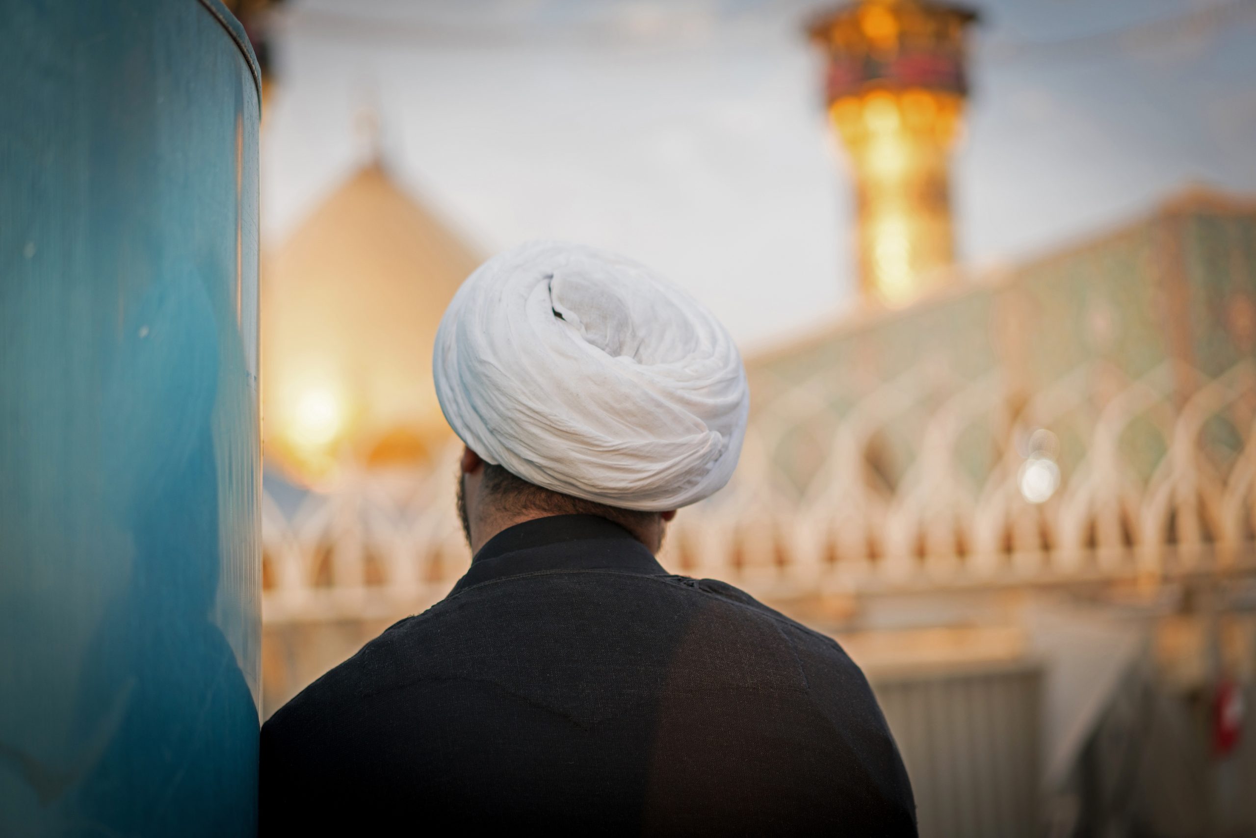 Muslim religious man in Karbala with Shrine of Imam Hussein in background
