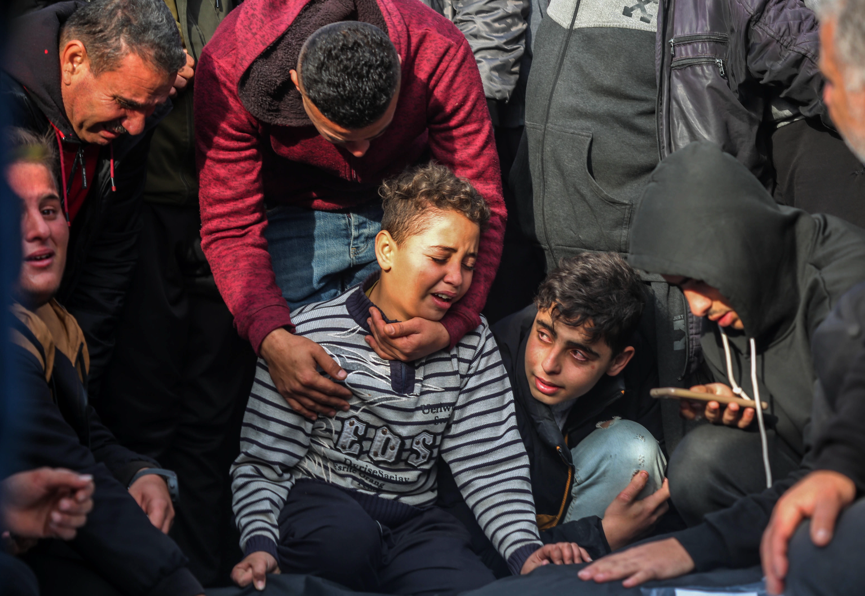 People mourn as they collect the bodies of Palestinians killed in an airstrike on December 20, 2023 in Khan Yunis, Gaza.