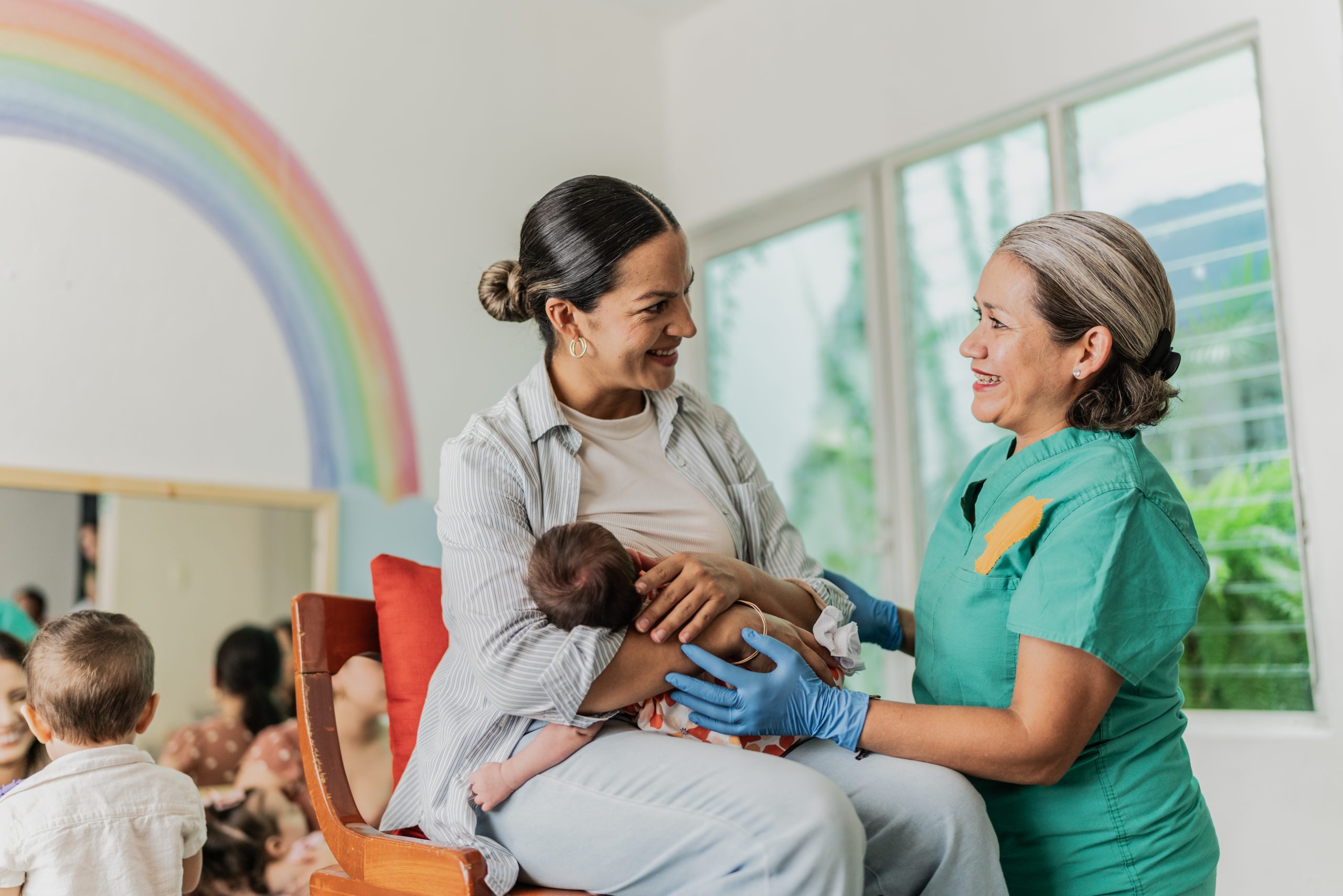 Mature woman learning to breastfeed her daughter in support group