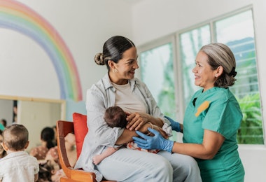Mature woman learning to breastfeed her daughter in support group