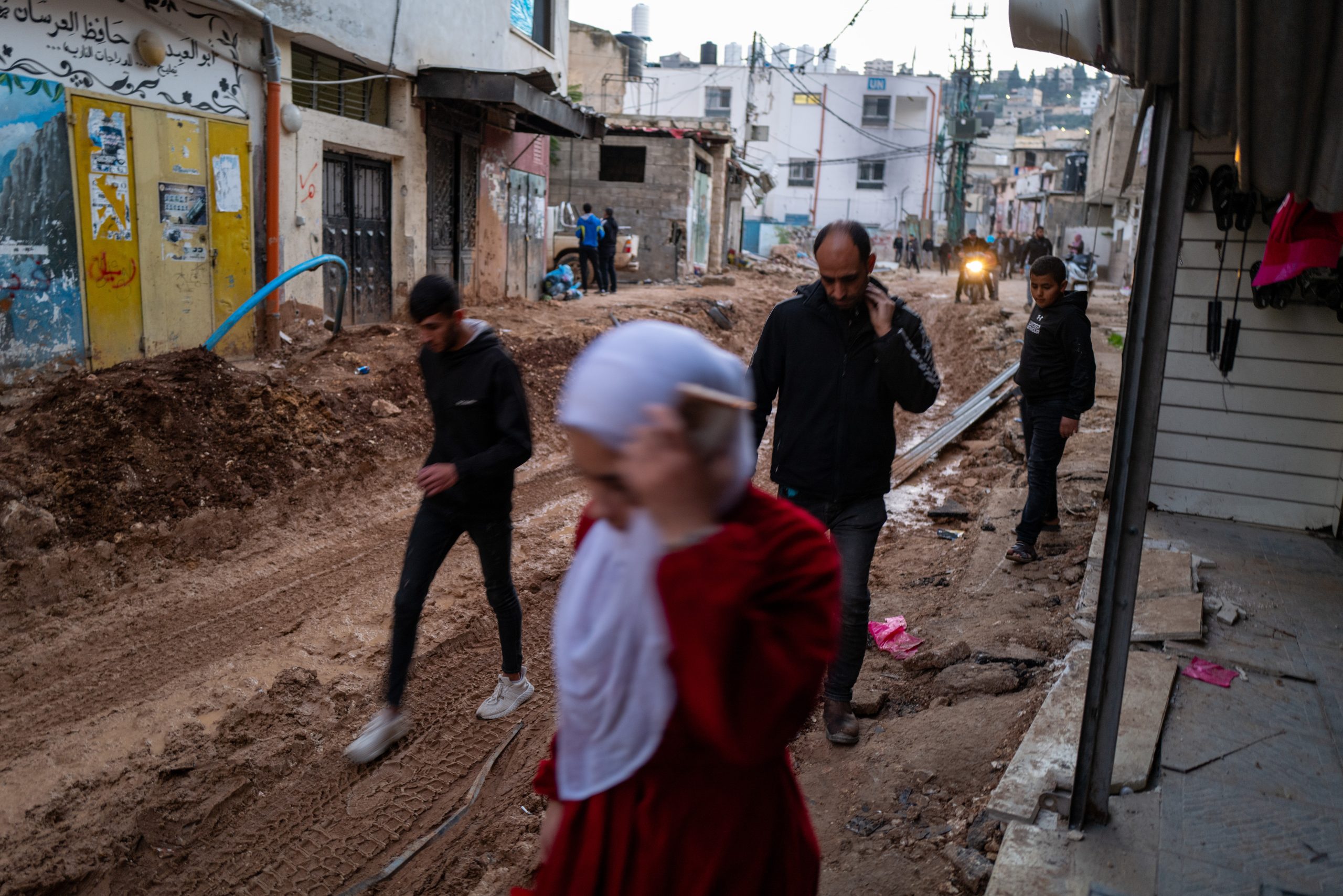 JENIN - DECEMBER 14: People walk through the damaged streets of Jenin after a muilti-day raid in the city by members of the Israeli Defense Forces (IDF) that left over 10 residents dead and wounded on December 14, 2023 in Jenin, Palestine. The West Bank city, a center of resistance to Israel, has been raided frequently in recent years resulting in many deaths of both civilians and fighters. Israel's war against Hamas that was sparked by the Oct. 7 attacks has also made life more volatile in East Jerusalem and the West Bank. Israeli forces here have stepped up raids on alleged militants, police have clashed with protesters, and there has been a rise in violent attacks on Palestinians by Israeli settlers. Last month, Hamas also claimed responsibility for a deadly shooting in Jerusalem by two brothers from the eastern part of the city. (Photo by Spencer Platt/Getty Images)