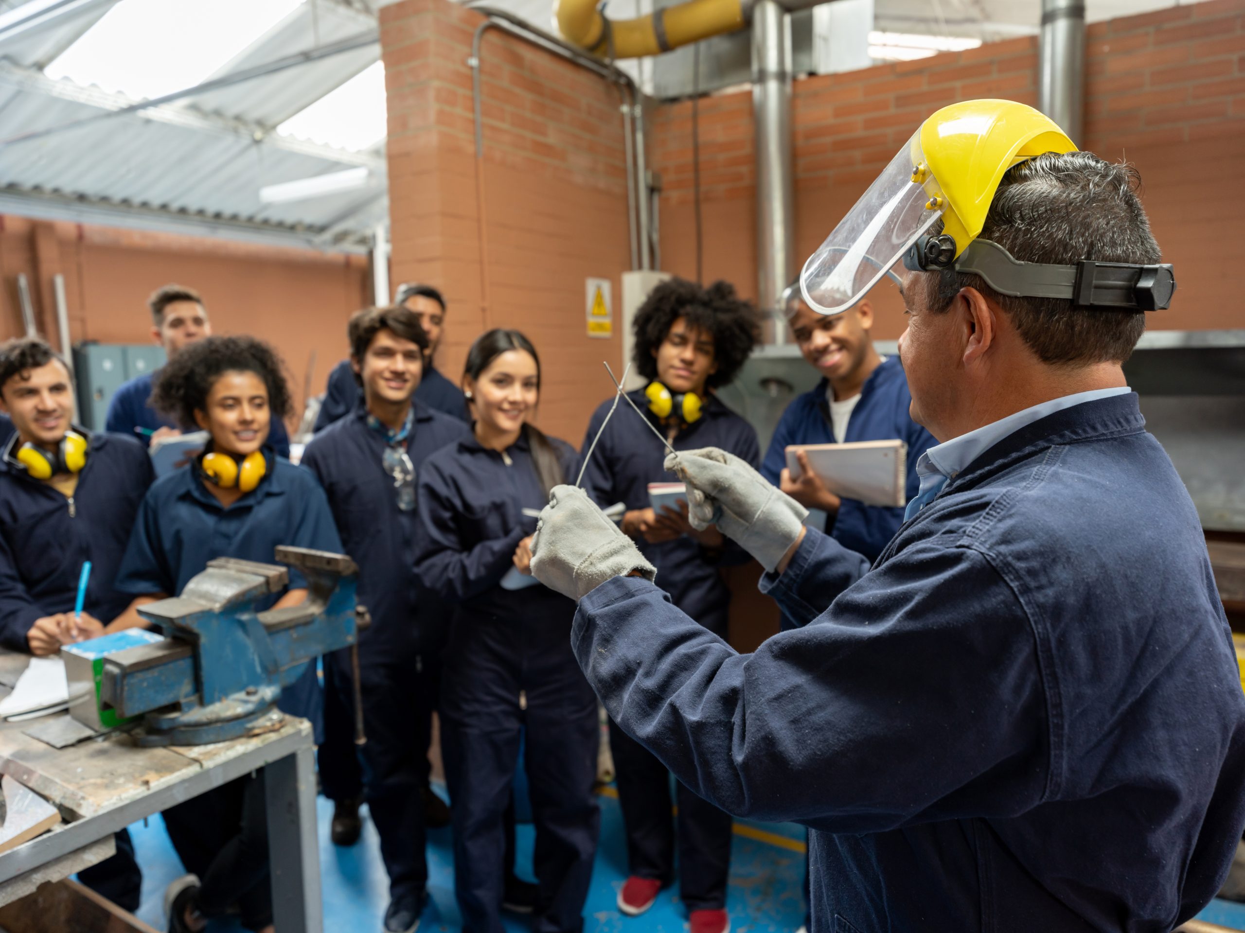 Group of college students in an engineering class looking at the teacher and paying attention - STEM education concepts
