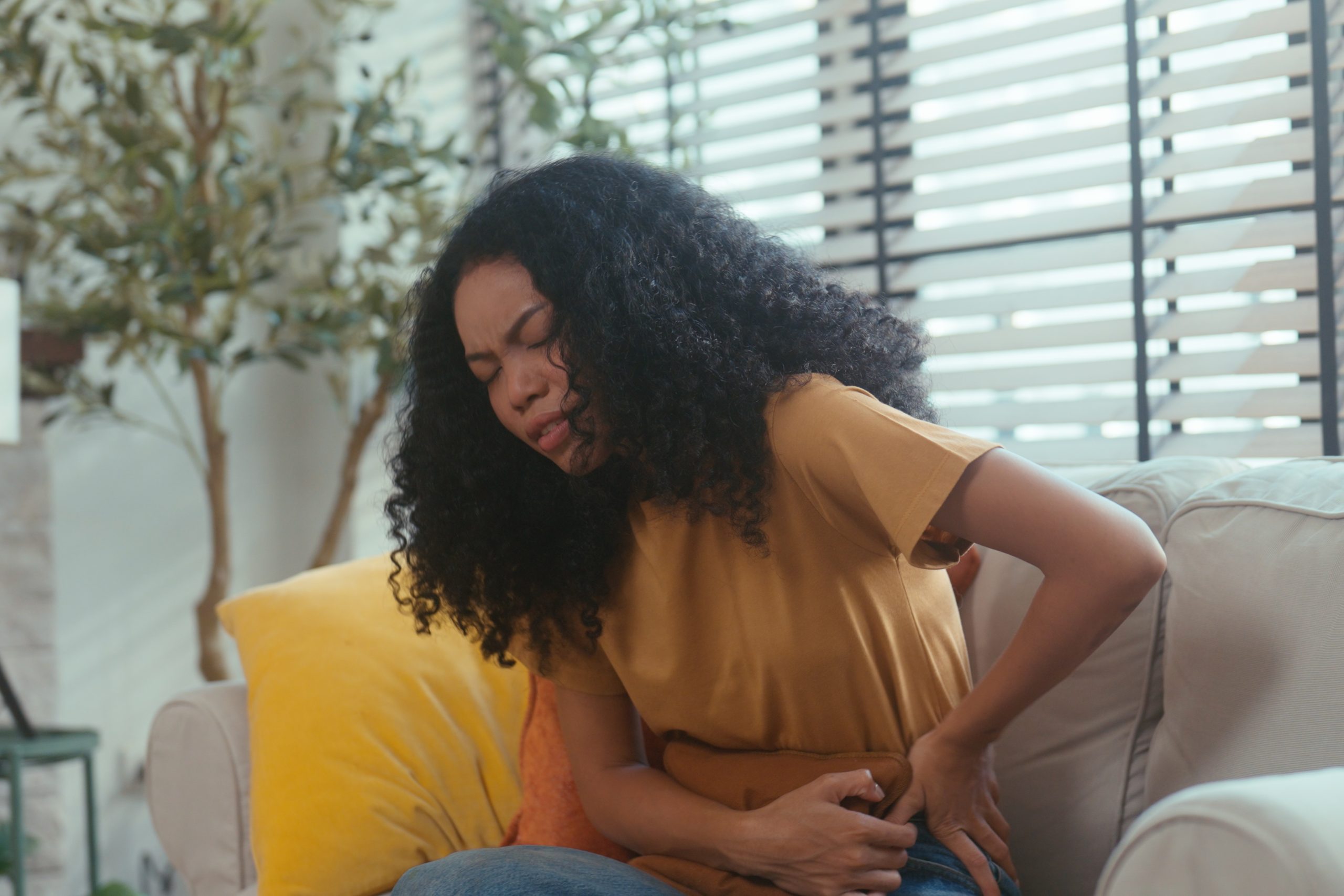 A focused medical professional in a home office environment, scrutinizing a prescription bottle while entering medical data on her laptop. The scene conveys her responsibility in ensuring accuracy in patient medication records, an essential part of healthcare management. The shelf of medical books in the background hints at a commitment to continuous learning and staying updated in the medical field. This footage is relevant for narratives on healthcare diligence, medication management, and the critical role of clinicians in patient safety