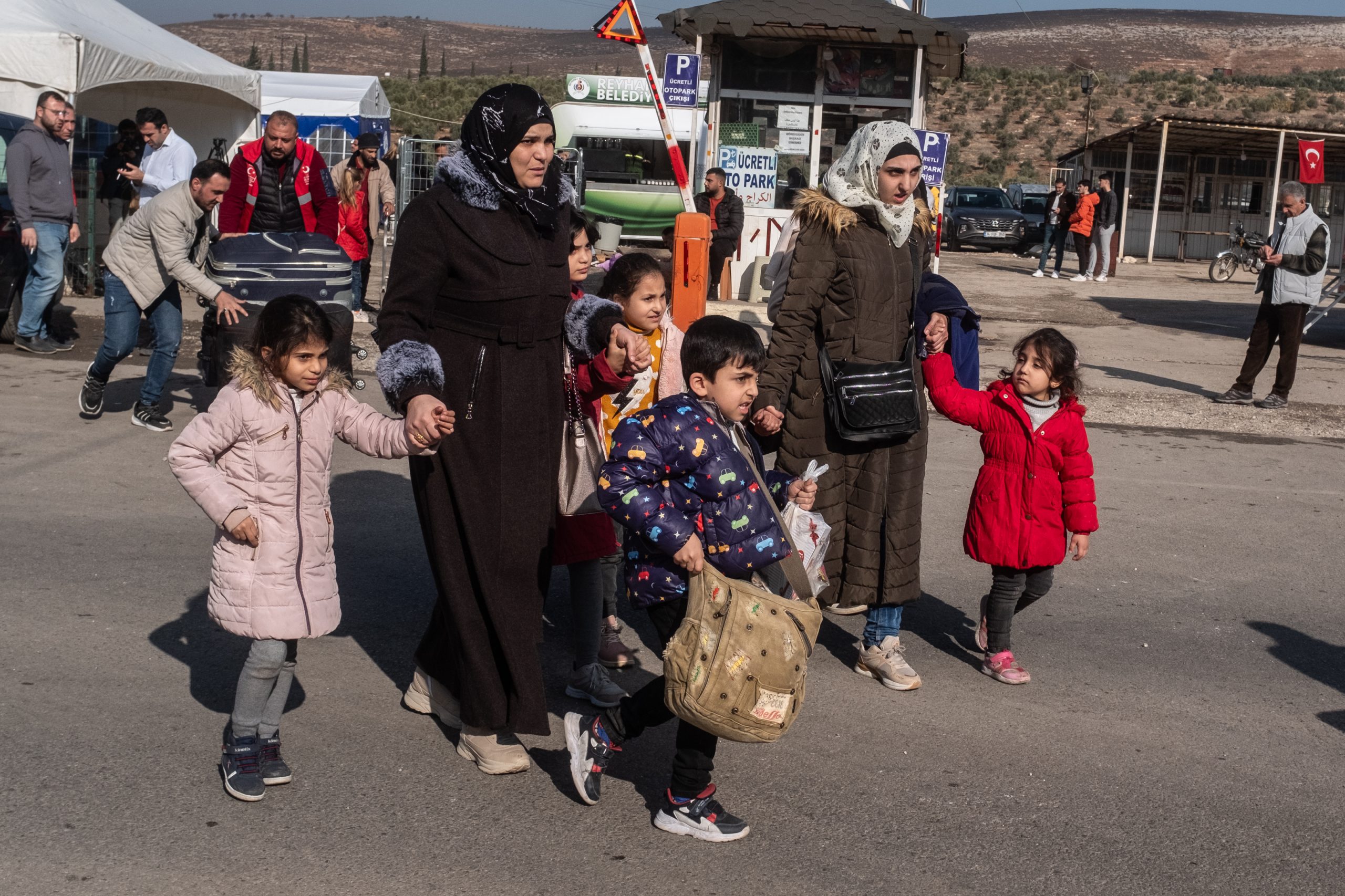 CILVEGOZU, TURKEY - DECEMBER 13: Syrian families living in Turkey walk towards the Cilvegozu border gate to cross into Syria after after Syrian rebels ousted President Bashar al-Assad on December 13, 2024 in Cilvegozu, Turkey. The fall of the Assad regime last week has prompted many Syrians in neighboring Turkey to try to reenter their home country. Turkey hosts a population of more than 3 million Syrian refugees, according to UNHCR statistics. (Photo by Burak Kara/Getty Images)