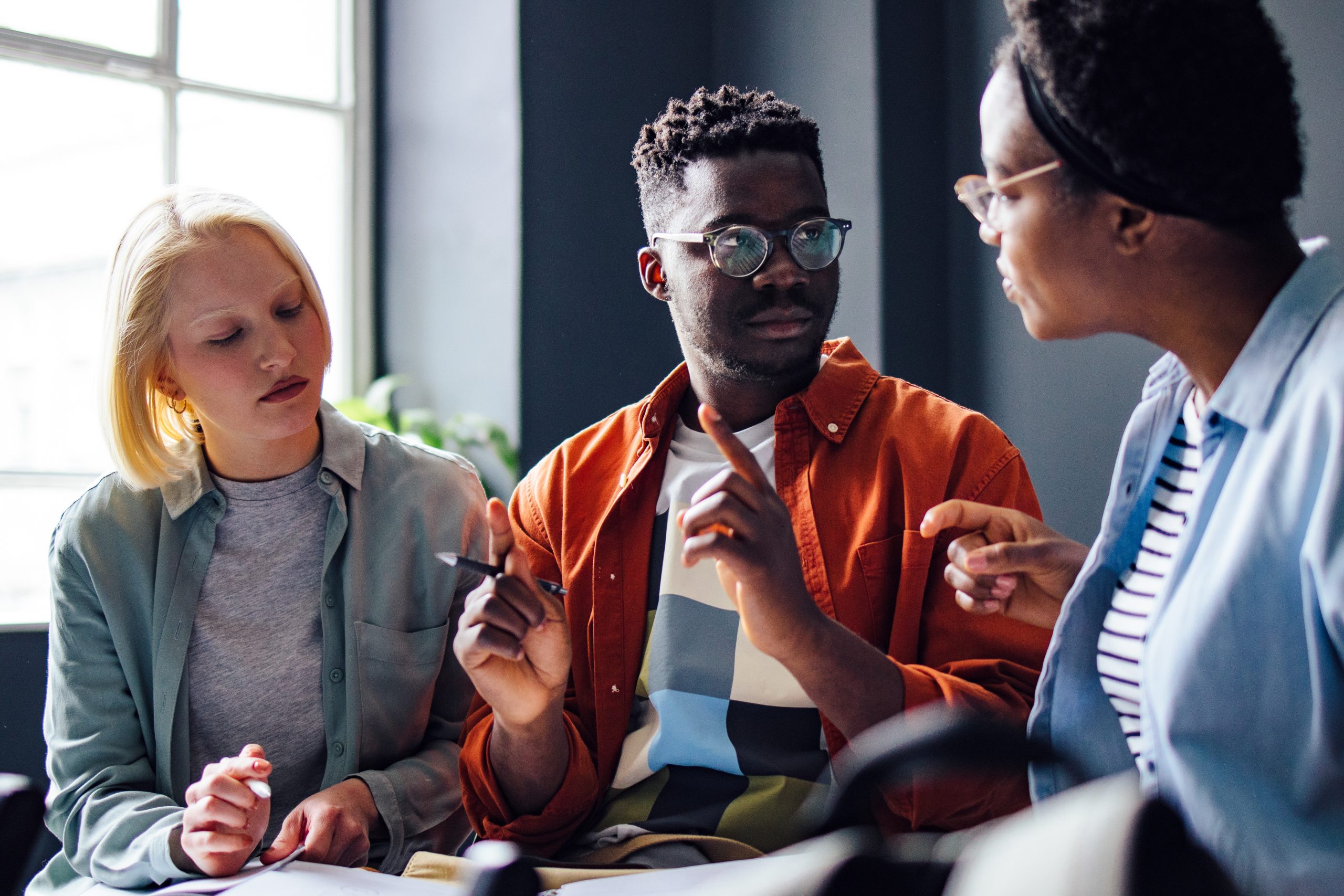 Serious African-American student explains something to his multi ethnic group of friends.