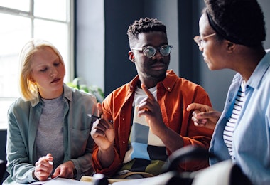 Serious African-American student explains something to his multi ethnic group of friends.