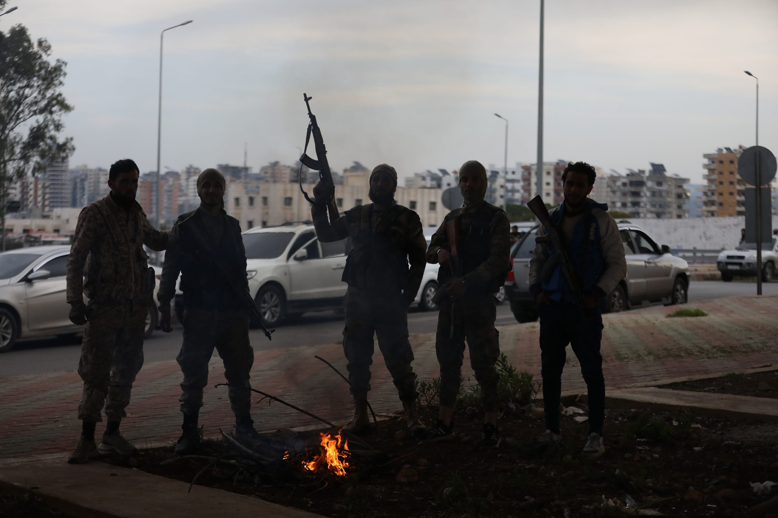 TARTUS, SYRIA - MARCH 7: Fighters with the new Syrian government stand around a fire on March 7, 2025 in the Tartus region of Syria. Dozens of people have been killed in clashes between loyalists of the deposed Assad regime and forces of the country's new rulers. It is the heaviest such fighting since Syrian rebels toppled the Assad regime last December. (Photo by Ali Haj Suleiman/Getty Images)
