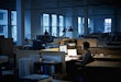 Businesswoman working at desk examining documents in empty office at night