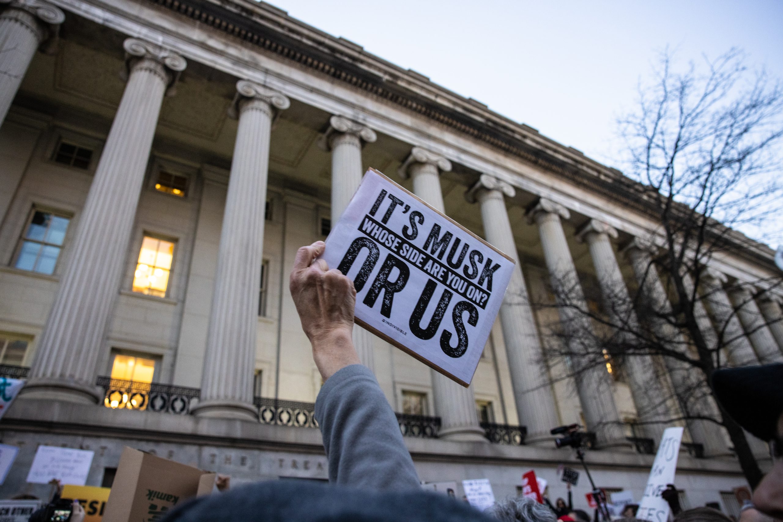 WASHINGTON, DC - FEBRUARY 4: A demonstrator holds up a sign during a rally in front of the U.S. Treasury Department in protest of Elon Musk and the Department of Government Efficiency on February 4, 2025 in Washington, DC. Several Democratic members of Congress joined the rally to protest Musk's access to the payment system of the Treasury, which houses the private information of millions of Americans. (Photo by Anna Rose Layden/Getty Images)