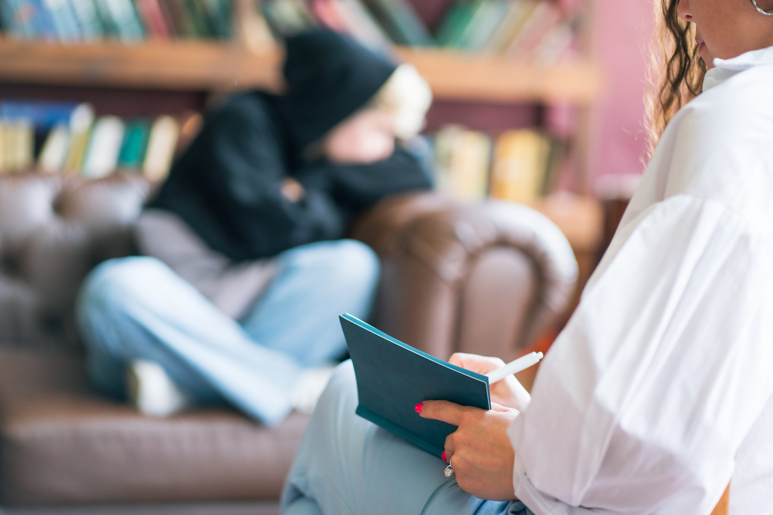 Teenagers gender stereotypes and relationship problems on psychotherapist couch, Blurred student in hoodie sit on couch and listen to female therapist