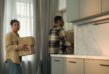 Frustrated sad couple ethnic woman man African American family upset worried home owners tenants moving out house with cardboard boxes bankruptcy leave apartment eviction divorce debt credit mortgage. High quality 4k footage