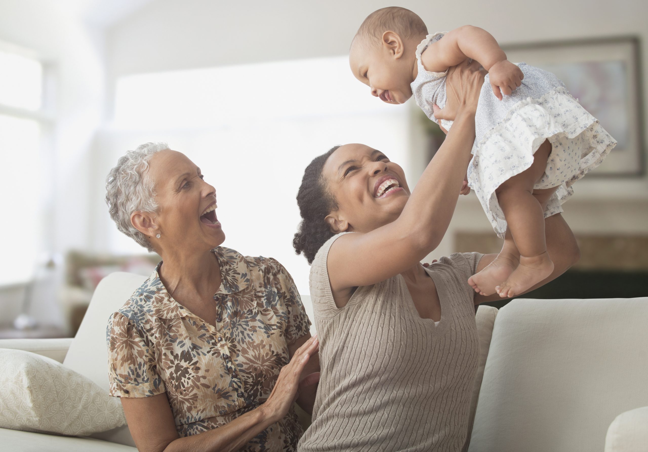 Three generations of women playing on sofa