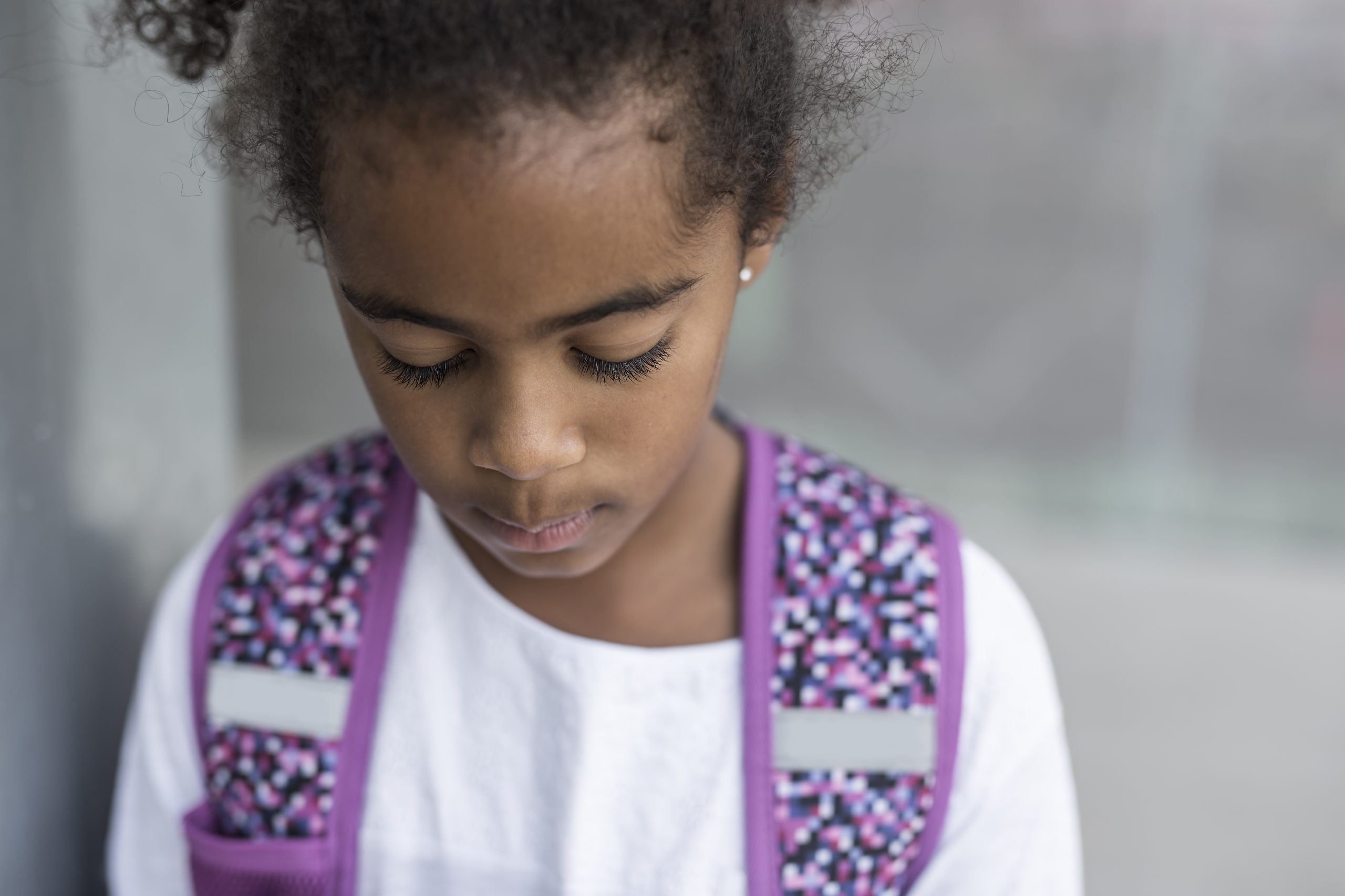 A cheerful african american primary school girl with backpack