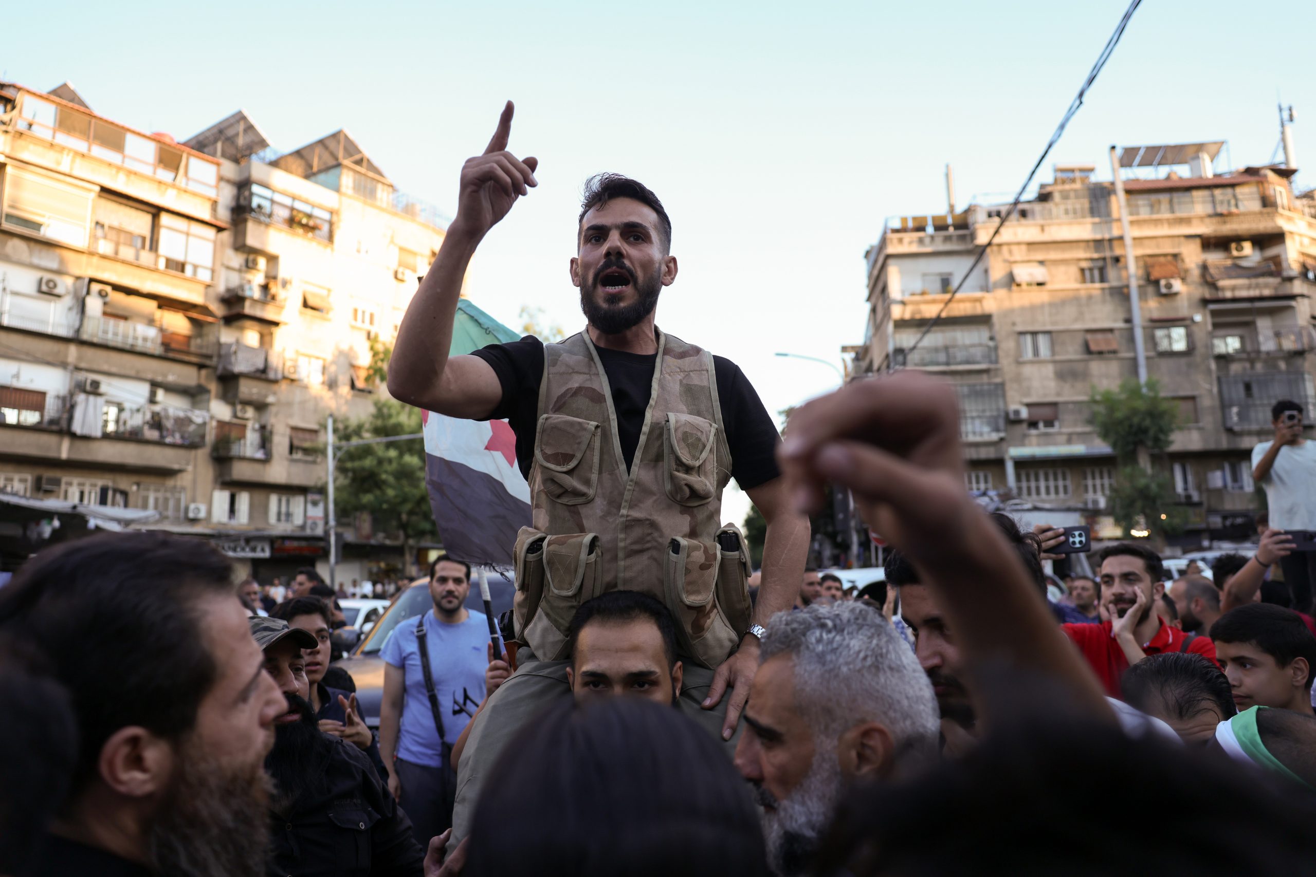 DAMASCUS, SYRIA - JULY 16: A man addresses demonstrators during a rally against Israeli intervention in Syria on July 16, 2025 in Damascus, Syria. A rally was held in Damascus in support of Syria's interim government and to denounce Israel's intervention following recent clashes between Syrian government forces and Druze militia in the southern Syrian city of Sweida, or Suwayda. A spokesperson from the Israeli Defense Forces (IDF) confirmed Wednesday that Israeli airstrikes targeted the headquarters of Syria's defence ministry and a site near the presidential palace in Damascus. (Photo by Ali Haj Suleiman/Getty Images)