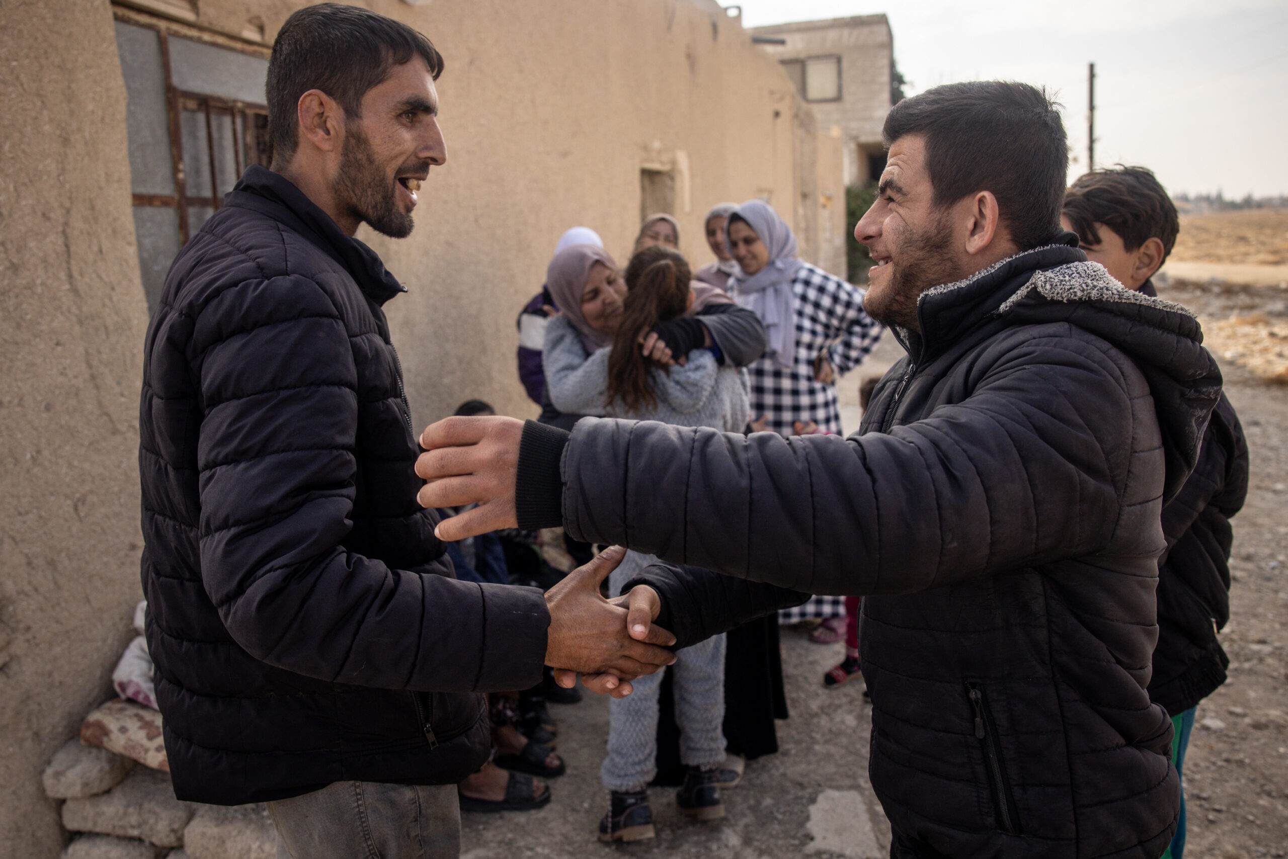 DAMASCUS, SYRIA - DECEMBER 21: Ahmed Muhammad Al-Nawa (L) is greeted by a neighbourhood friend after returning home from Lebanon to his family’s home in the village of Harran for the first time in 10-years on December 21, 2024 in Damascus, Syria. 36-year-old Ahmed, was imprisoned and tortured by the regime for a year and half in the Mezzah Military Prison in 2012-2013, after his release, his wife and daughter were displaced from their home in the village of Harran, Eastern Ghouta, Damascus, during the Assad regime’s siege of the region in 2014. They fled to Lebanon where they have been living in a tent in the Hosh Al-Hareem camp for the past 10-years. Ahmed’s mother Umm Marwan stayed behind in Syria due to a heart condition that stopped her from travelling. While living in Lebanon, Ahmed and his wife had four more children that were born in Lebanon and have never meet their grandmother, other relatives or seen the family home. After the fall of the regime Ahmed decided to return home bringing all his possessions from Lebanon and giving his mother the chance to meet her grandchildren face to face for the first time.  (Photo by Chris McGrath/Getty Images)